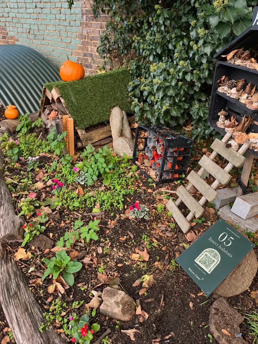 Sign 05 against the bug house, pumpkins on its roof